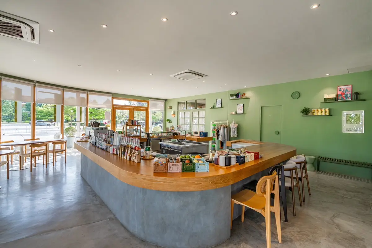 Long counter and a pale green wall in a room with large windows.