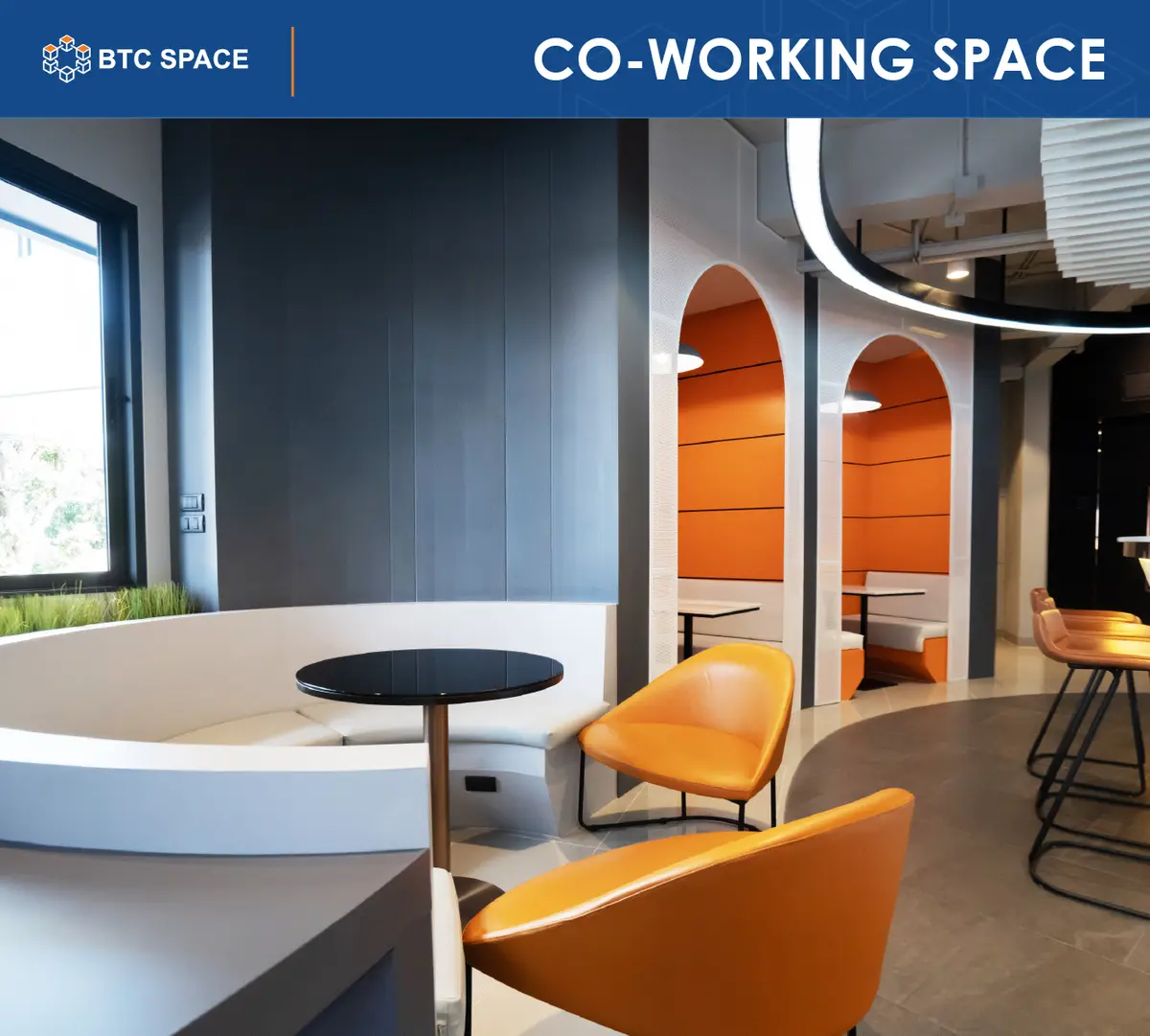 Curved white booth seating with orange chairs and a small round table.