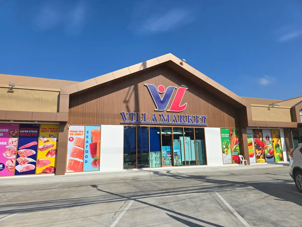 Villa Market store front with a pitched wooden roof and bright window posters.