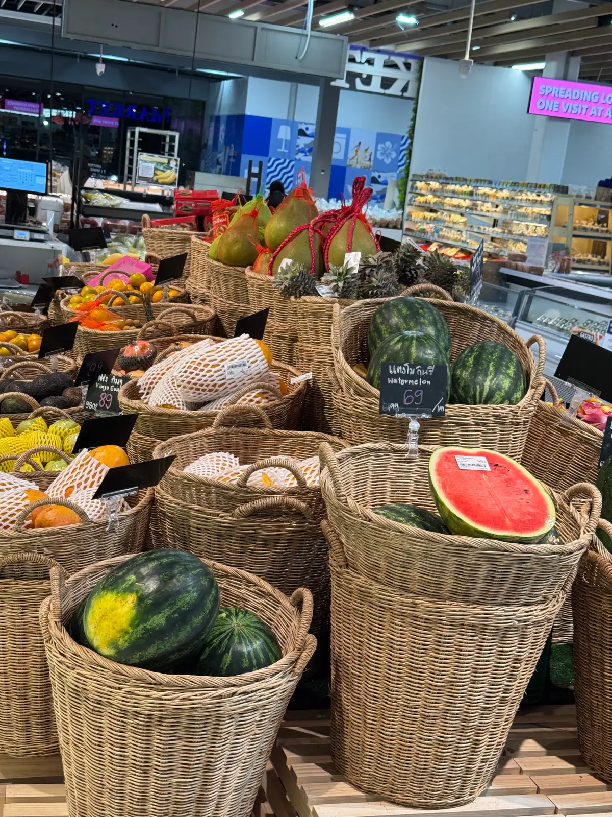 Wicker baskets of watermelons, melons and tropical fruit.