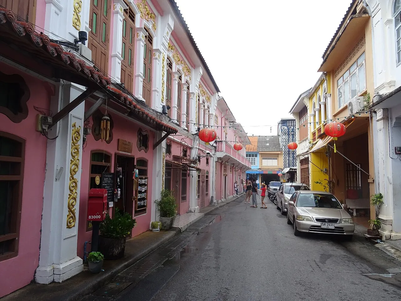 Narrow Soi Rommanee lined with pastel shophouses and red lanterns hanging overhead.