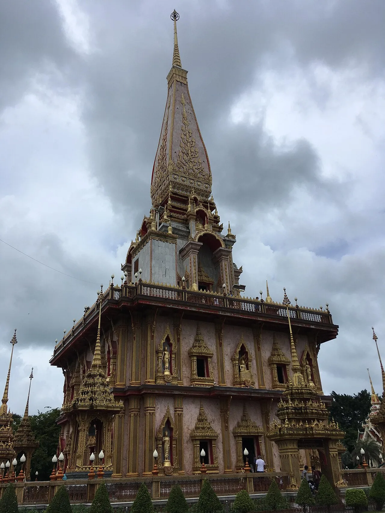 The Great Stupa at Wat Chalong, a tall tiered pagoda with a gold-patterned spire and balcony terraces.